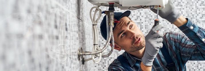 Handwerker repariert Boiler mit Schraubendreher